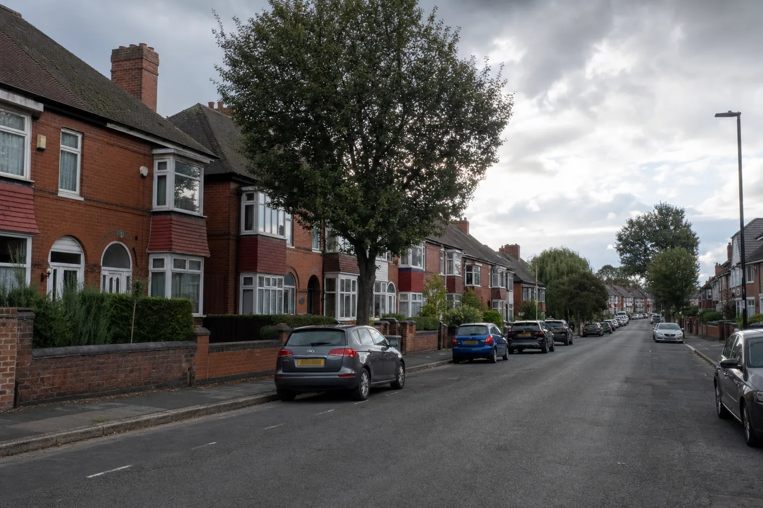 A West Midlands residential street of red-brick semi-detached houses with bay windows